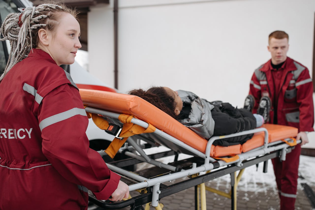 Emergency responders assisting a patient on a stretcher, highlighting teamwork and medical care.